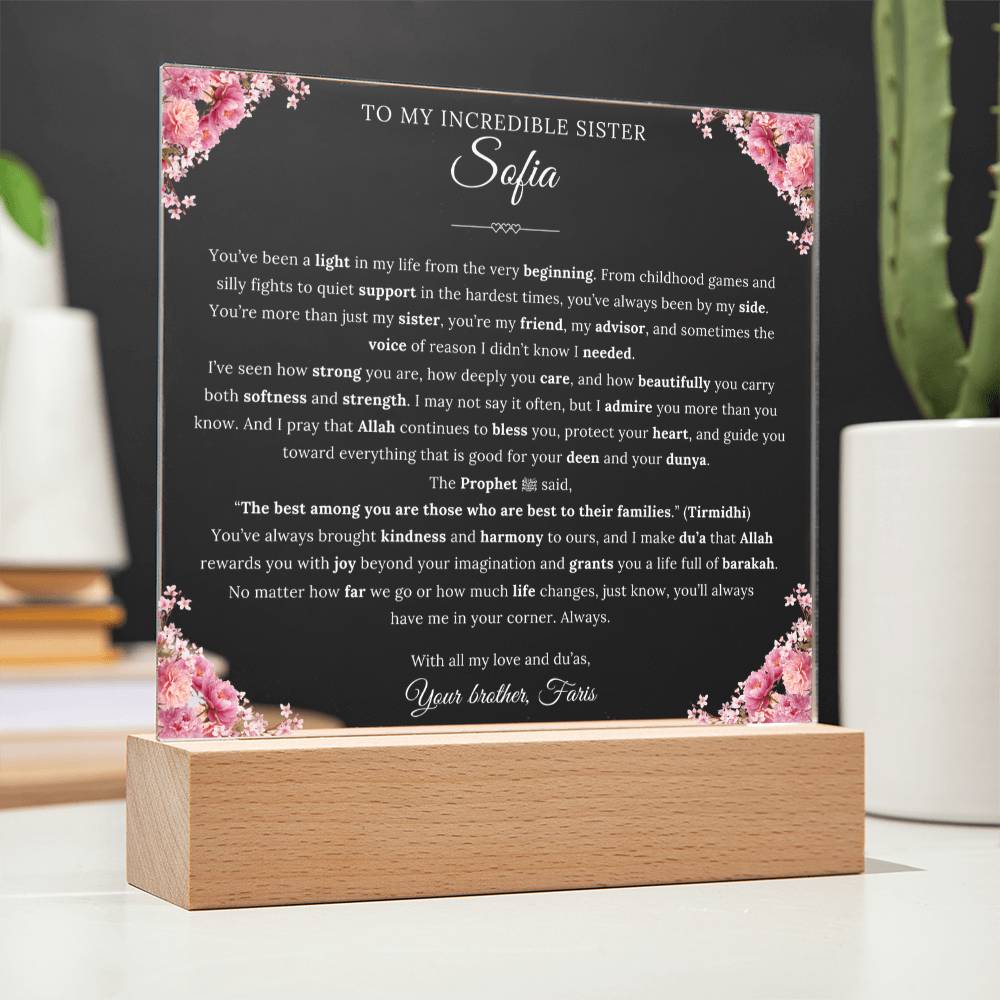 The image displays a heartfelt message on a wooden stand, written in a cursive font, with a floral border. The message is addressed to "Sofia" and expresses love and support from the speaker's family.