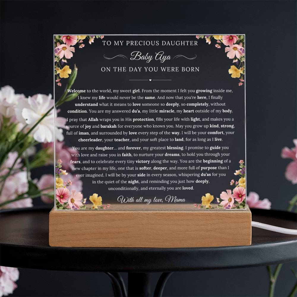 The image displays a heartfelt message for a precious daughter, Baby Aya, written on a wooden stand with a floral border. The message is a beautiful tribute to the newborn baby, expressing love and affection from the mother to her daughter.